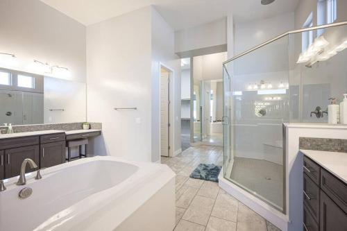 a white bathroom with a tub and a shower at Luxury home close to everything in Las Vegas