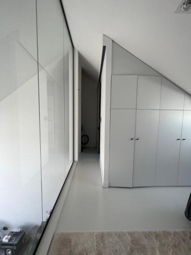 ein leeres Zimmer mit weißen Schränken und einem Flur in der Unterkunft Penthouse In the Center of Antwerp With private Elevator. in Antwerpen