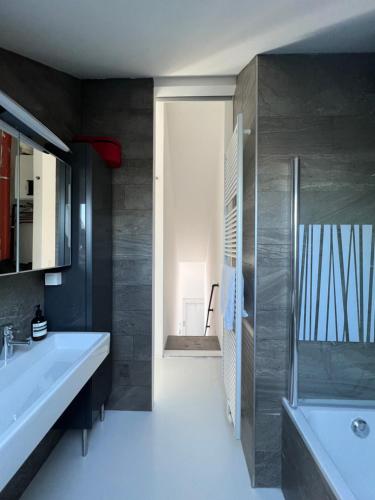 ein Badezimmer mit einem Waschbecken und einer Badewanne in der Unterkunft Penthouse In the Center of Antwerp With private Elevator. in Antwerpen