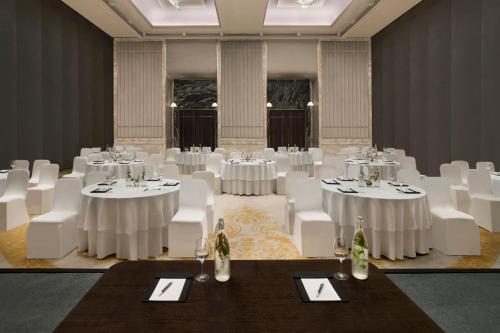 a room with white tables and white chairs in a room at The Westin Pune Koregaon Park in Pune