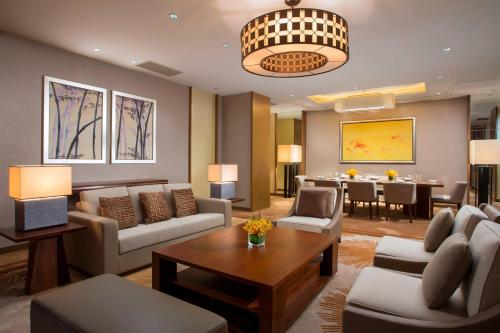 a living room with couches and a dining room at Sheraton Bailuhu Resort, Huizhou in Huizhou