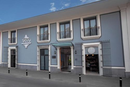 a gray building with windows and doors on a street at TRES79 Hotel Boutique Orizaba in Orizaba