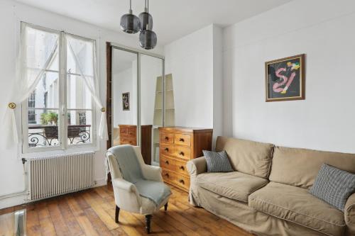 a living room with a couch and a chair at Unit 016 Marais Turenne in Paris