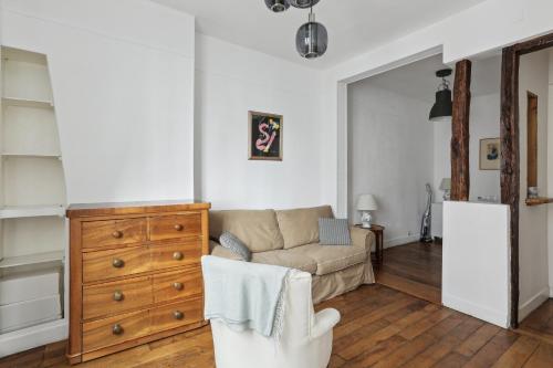 a living room with a couch and a dresser at Unit 016 Marais Turenne in Paris