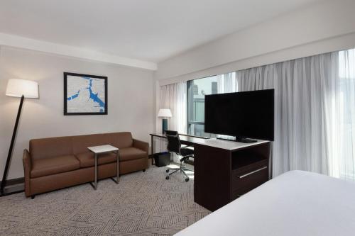a hotel room with a bed and a couch and a television at Residence Inn by Marriott Boston Back Bay/Fenway in Boston