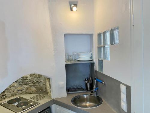 a small kitchen with a sink and a counter at Cyclops House in Serifos Chora