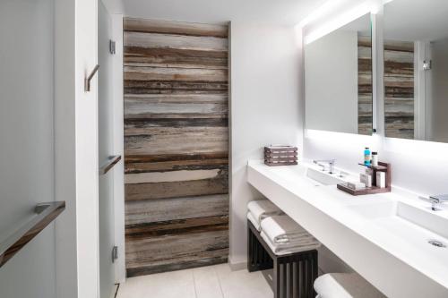 a bathroom with a wooden accent wall at The Row Hotel at Assembly Row, Autograph Collection in Somerville