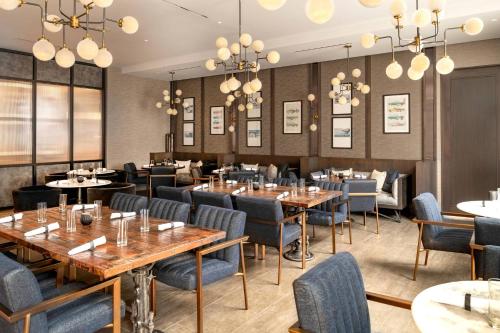 a restaurant with tables and chairs and chandeliers at The Row Hotel at Assembly Row, Autograph Collection in Somerville