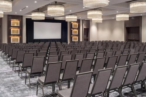 a lecture hall with chairs and a projection screen at The Row Hotel at Assembly Row, Autograph Collection in Somerville