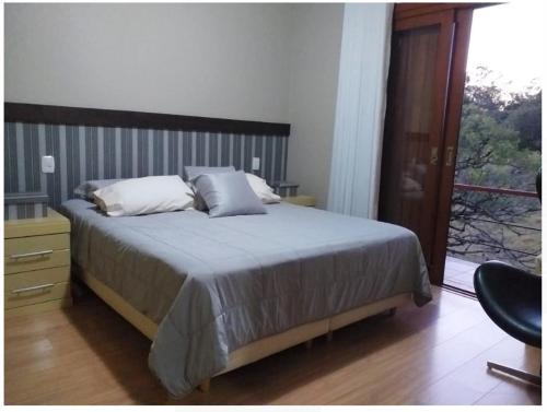 a bedroom with a bed and a large window at Suíte em casa de campo in Carlos Barbosa
