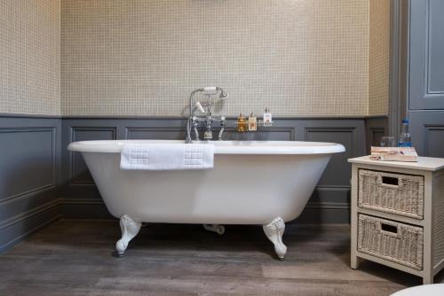 a white bath tub with a faucet in a bathroom at Cringletie House in Peebles