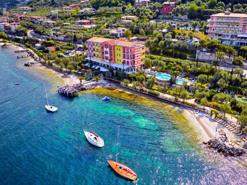 an aerial view of a beach with boats in the water at Belfiore Park Hotel****S in Brenzone sul Garda