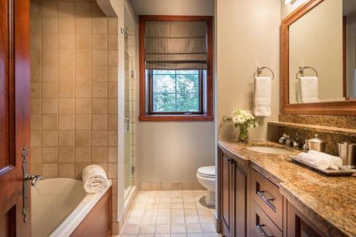 a bathroom with a tub and a toilet and a sink at Bondurant 95-8 / COZY and LUXURIOUS 3 bedroom in Mont-Tremblant
