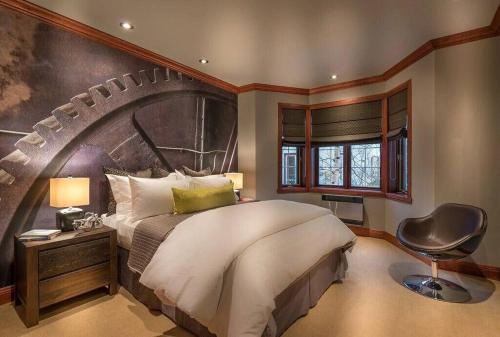 een slaapkamer met een groot bed en een stoel bij Bondurant 95-8 / COZY and LUXURIOUS 3 bedroom in Mont-Tremblant