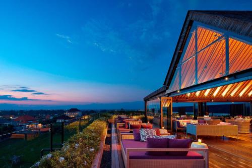 a patio with couches and tables on a building at Four Points by Sheraton Bali, Seminyak in Seminyak