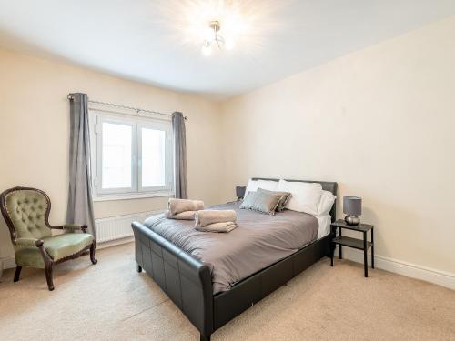 a bedroom with a bed and a chair and a window at The Coffee House in Coleford