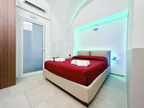 um quarto com uma cama com um cobertor vermelho em Messapica Home em Ceglie Messapica