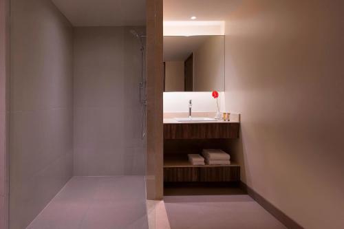 a bathroom with a shower and a sink and a mirror at Sheraton Hyderabad Hotel in Hyderabad