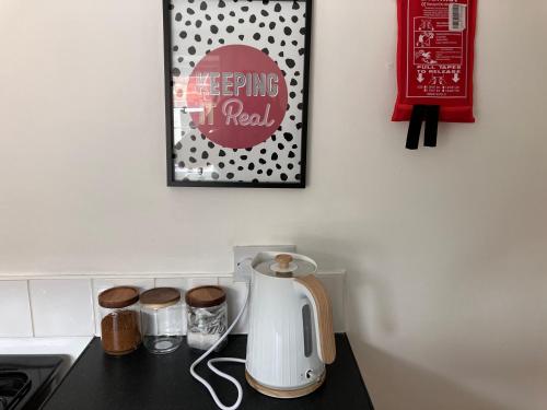 a kitchen counter with a tea kettle and a picture at Romford Cottage - Close to Centre, Hospital CrownWorks Studio Nissan and Stadium of Light in Sunderland