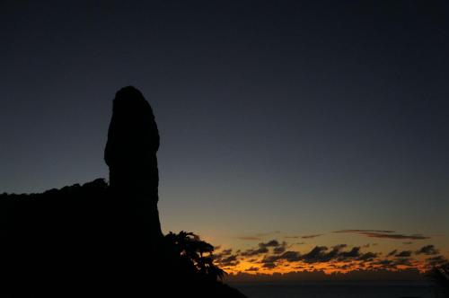 a silhouette of a hill with the sunset in the background at Casa Makaira in Fernando de Noronha