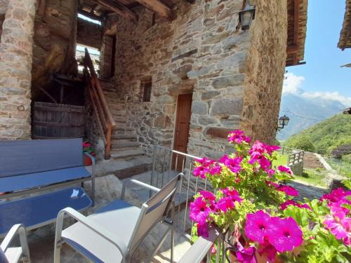 Casa con balcón con flores rosas en Bed & Breakfast La Crotta, en Pont-Saint-Martin