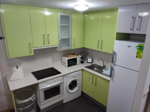 eine Küche mit grünen Schränken und einem weißen Kühlschrank in der Unterkunft Apartamento Estrella de Teruel in Teruel