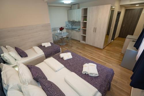 a living room with two white couches and a kitchen at Bed&Breakfast Novalis in Novalja