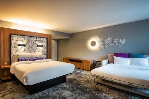 ブリュッセルにあるアロフト ブリュッセル シューマンのベッド2台と窓が備わるホテルルームです。