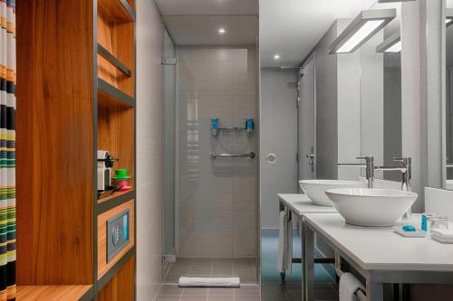 y baño con 2 lavabos y ducha. en Aloft Brussels Schuman, en Bruselas