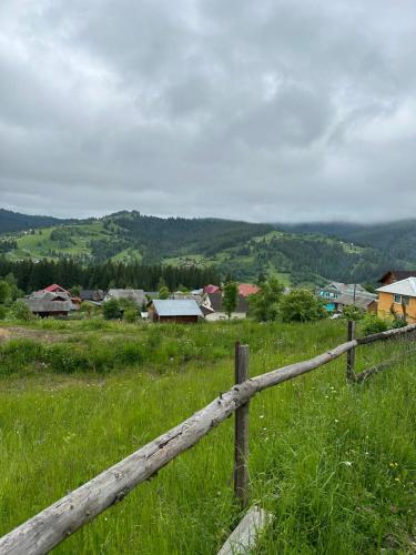 a wooden fence in the middle of a field at Байка Карпат in Vorokhta