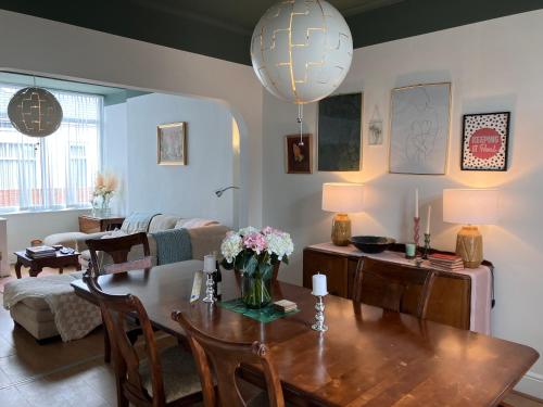 a living room with a table with flowers on it at Romford Cottage - Close to Centre, Hospital CrownWorks Studio Nissan and Stadium of Light in Sunderland
