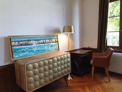 un salon avec une télévision à écran plat au-dessus d'un canapé dans l'établissement Les Volets Bleus de Veules Les Roses, à Veules-les-Roses