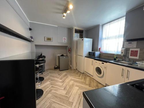 a kitchen with a washer and dryer in it at Petticoat Accommodations in London