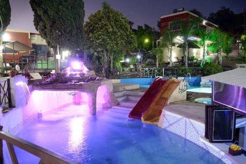 a swimming pool at night with a slide at Complejo Los Cipreses in Villa Carlos Paz