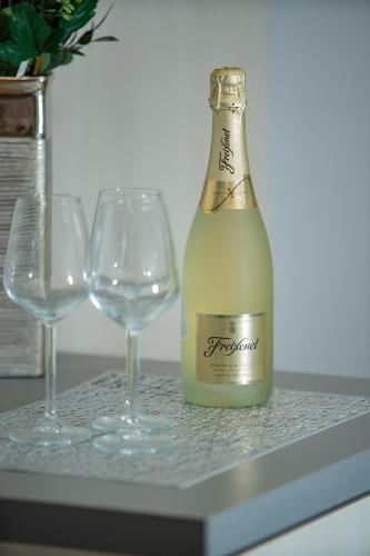 a bottle of wine and two wine glasses on a counter at Bed&Breakfast Novalis in Novalja