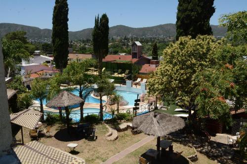 a view of a resort with a swimming pool and trees at Complejo Los Cipreses in Villa Carlos Paz