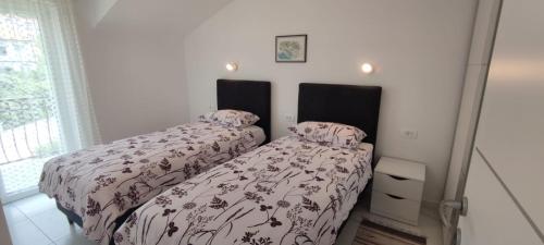 two beds sitting next to each other in a bedroom at Apartments INBOX in Kostrena