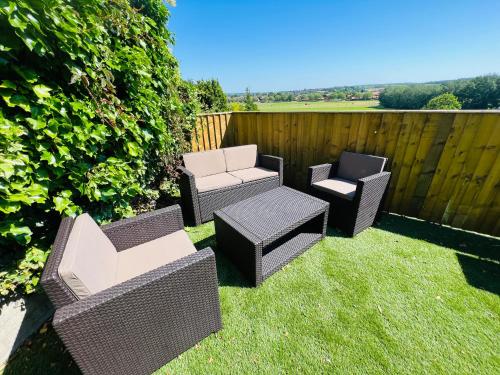 four wicker chairs and chairs sitting on the grass at Fox House in Rotherham
