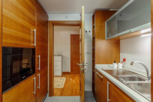 uma cozinha com um lavatório e um micro-ondas em Charmoso Apartamento Sacavém em Sacavém
