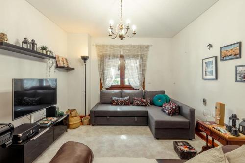 a living room with a couch and a flat screen tv at Charmoso Apartamento Sacavém in Sacavém