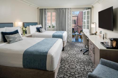 Cette chambre comprend deux lits et une télévision. dans l'établissement Four Points by Sheraton French Quarter, à La Nouvelle-Orléans
