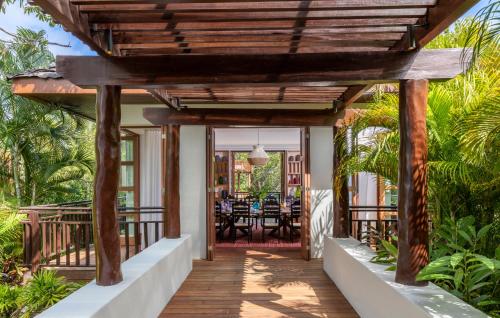 a wooden walkway leading to a patio with a dining table at Fairmont Mayakoba in Playa del Carmen