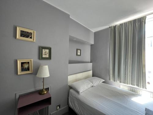 a small bedroom with a bed and a window at Petticoat Accommodations in London