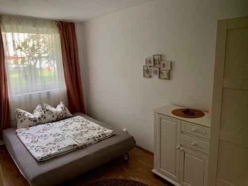 um pequeno quarto com uma cama e uma janela em Apartament 3 camere Joy em Ocna-Mureşului