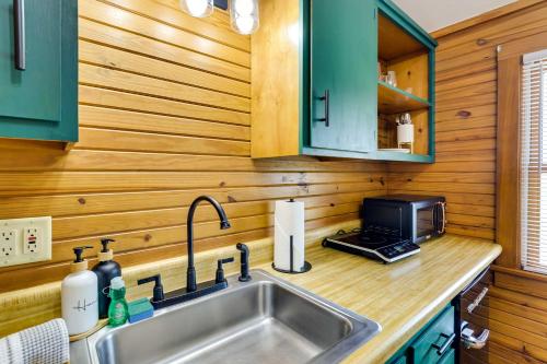 a kitchen with a sink and a microwave at Scenic Eureka Springs Cabin Rental with Balcony! in Garfield