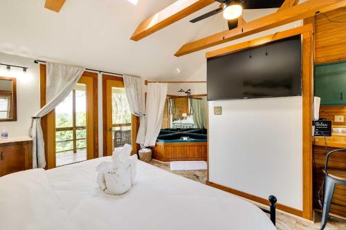 a bedroom with a white bed with a stuffed animal on it at Scenic Eureka Springs Cabin Rental with Balcony! in Garfield