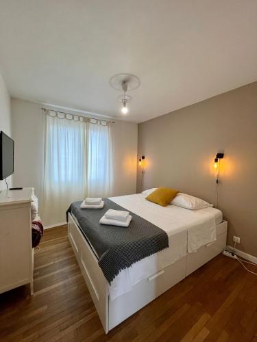 une chambre avec un grand lit avec deux serviettes dessus dans l'établissement T4 Boulevard Vigenal - DABNB, à Limoges