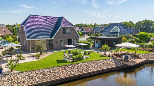 an aerial view of a house next to a river at B&B de Wiekeborg in Oude Pekela