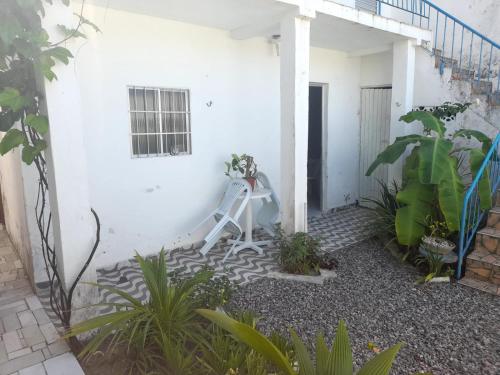 a white house with a white staircase in a courtyard at Ap 04-A 50 Metros da Praia Flats Mobiliados para 2 Pessoas in Paulista