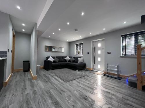 uma sala de estar com um sofá preto e uma lareira em Entire Two Bedroom Guest Home Free Parking em Nottingham